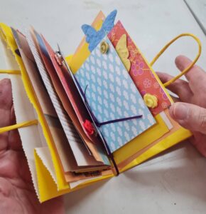 A finished journal, made from colourful paper bags, recycled paper and old envelopes