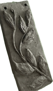 A finished clay tile with a leaf motif